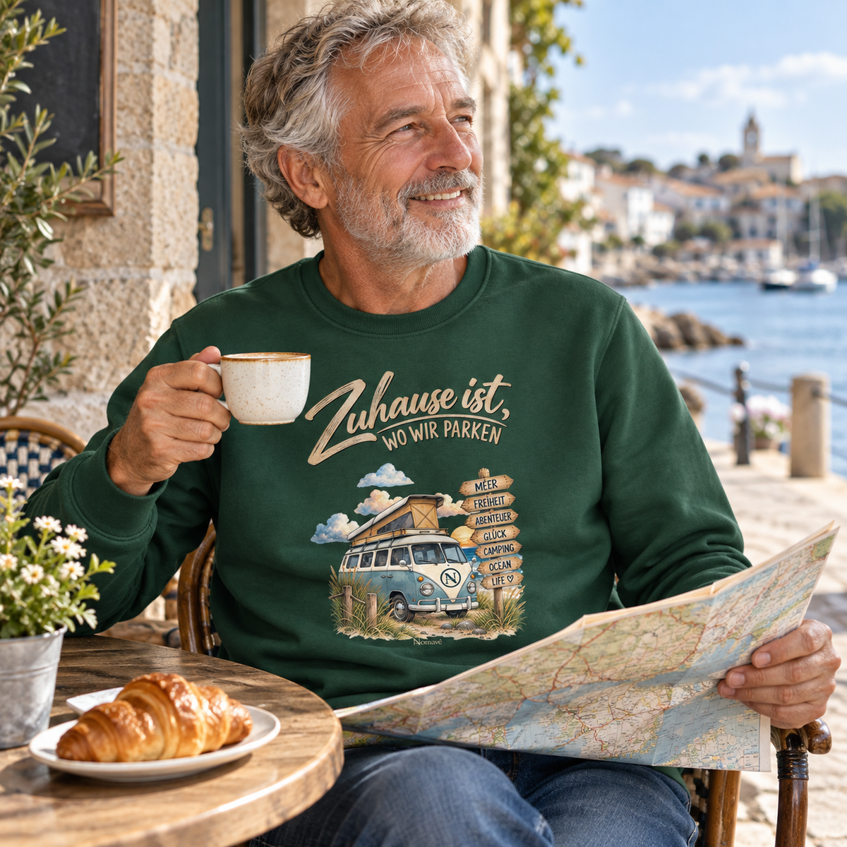 Bottle-Green Bio-Unisex-Sweatshirt mit Vanlife-Motiv im Café eines Küstenorts