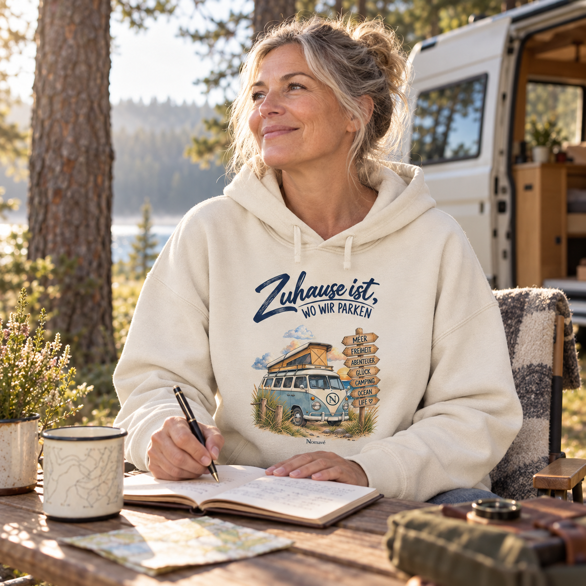 Natural Raw Damen Bio Boxcut Hoodie mit Van-Life-Motiv beim Schreiben im Reisetagebuch am Campingplatz