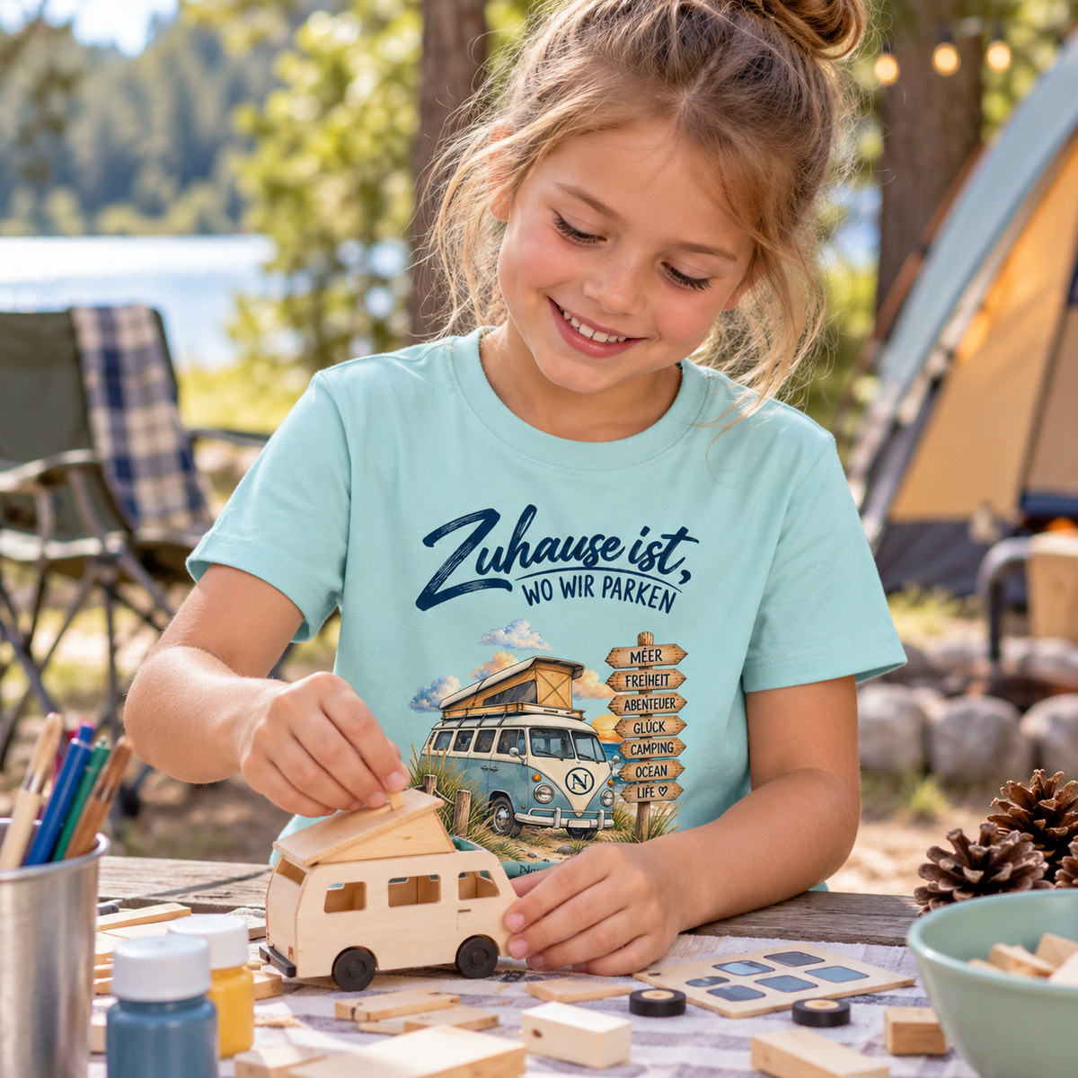 Caribbean Blue Kinder Bio Shirt mit Van-Life-Frontprint beim Basteln am Campingplatz