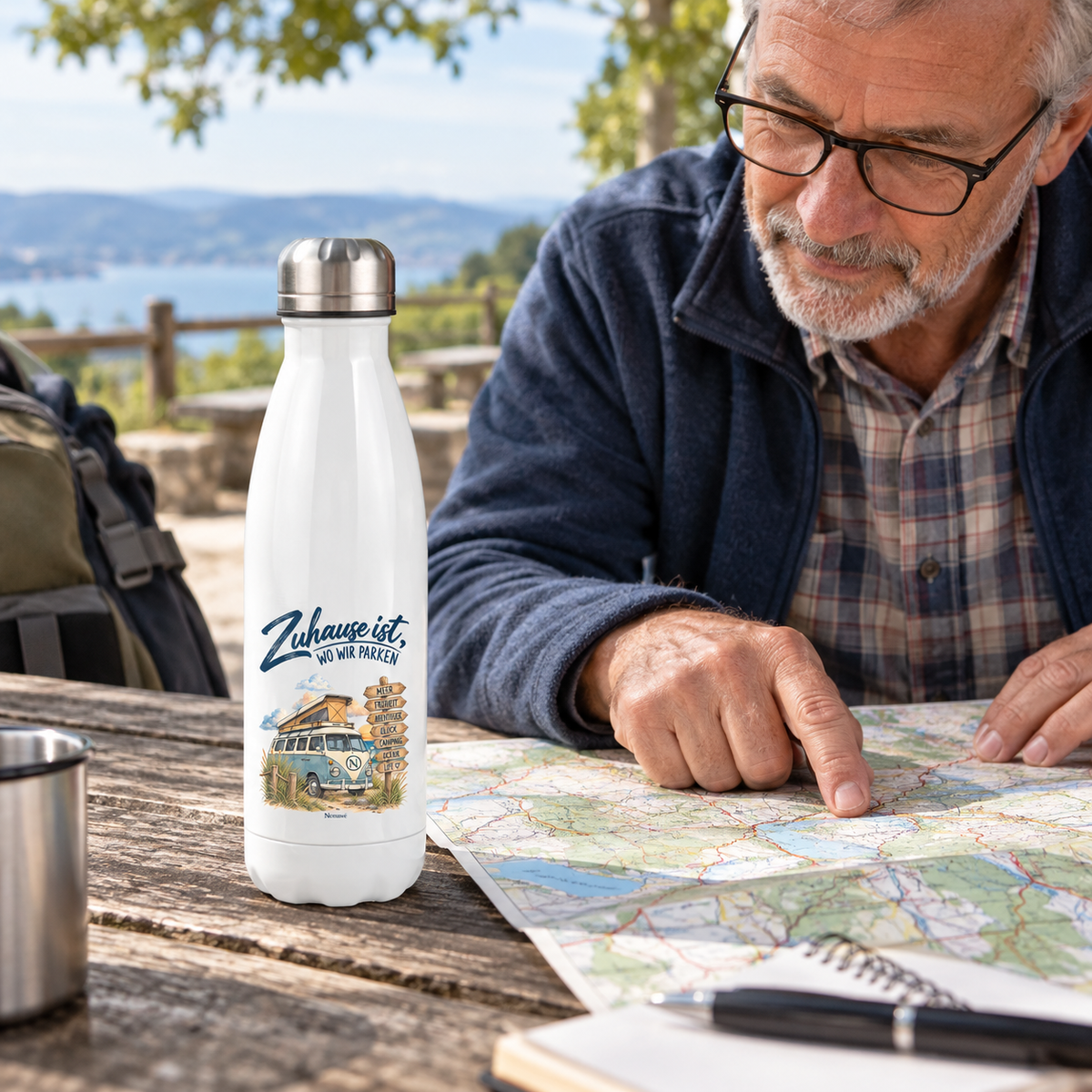 Weiße Vanlife Thermoflasche mit Zuhause-ist-wo-wir-parken-Motiv bei der Routenplanung